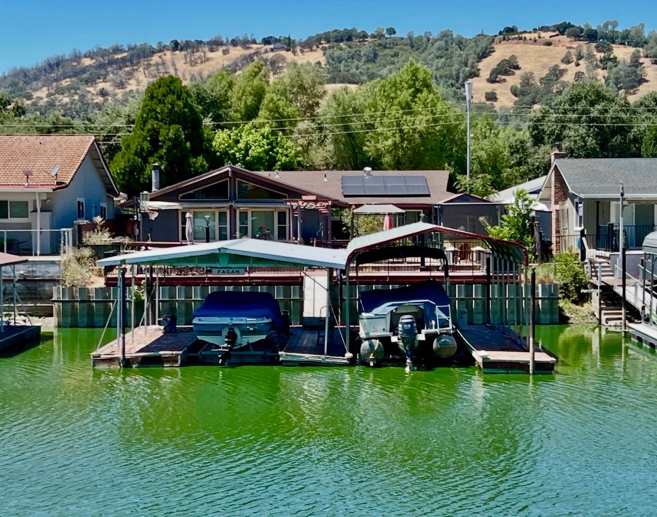 Back canal view of 554 Keys Blvd, Clearlake Oaks, with boat lifts and dock